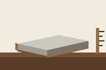 A concrete slab with wooden forms beside a depth ruler